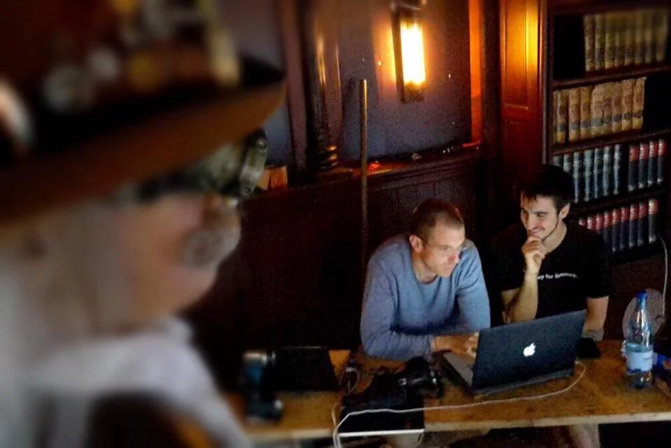 Gerard Pastor and Carles Bernal working in the background inside an attraction’s library, programming an animatronic that appears in the foreground slightly out of focus.