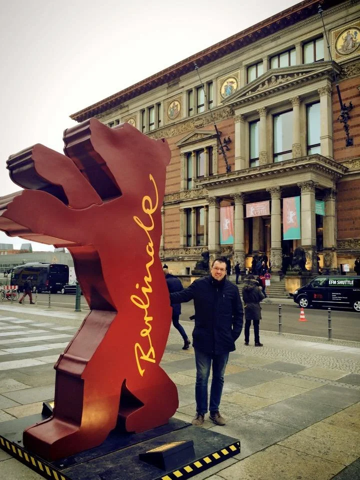 Gerard Pastor posing next to the red Berlin Bear sculpture for the Berlinale.