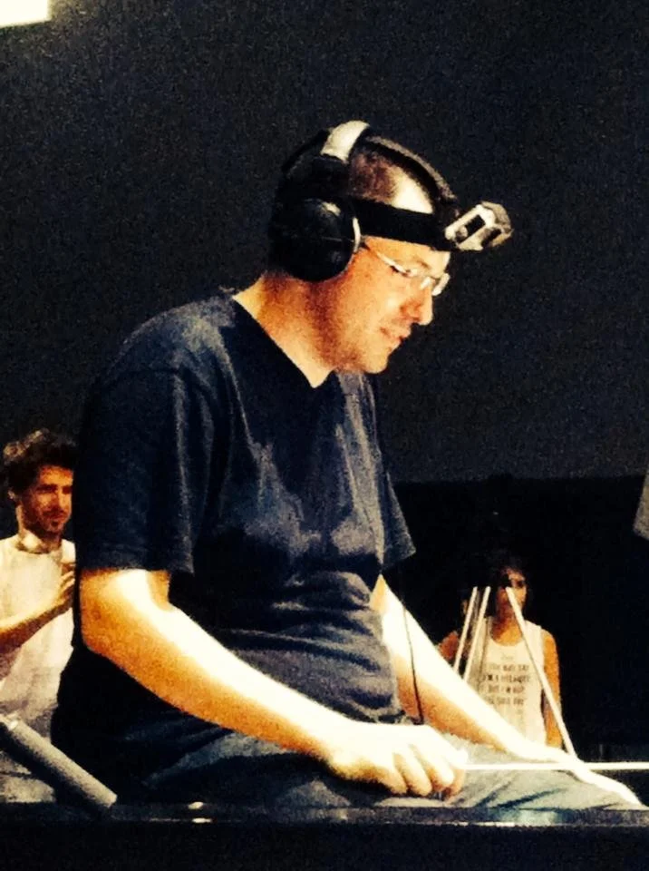 Gerard Pastor on a director’s stool, smiling, with a GoPro on his head.