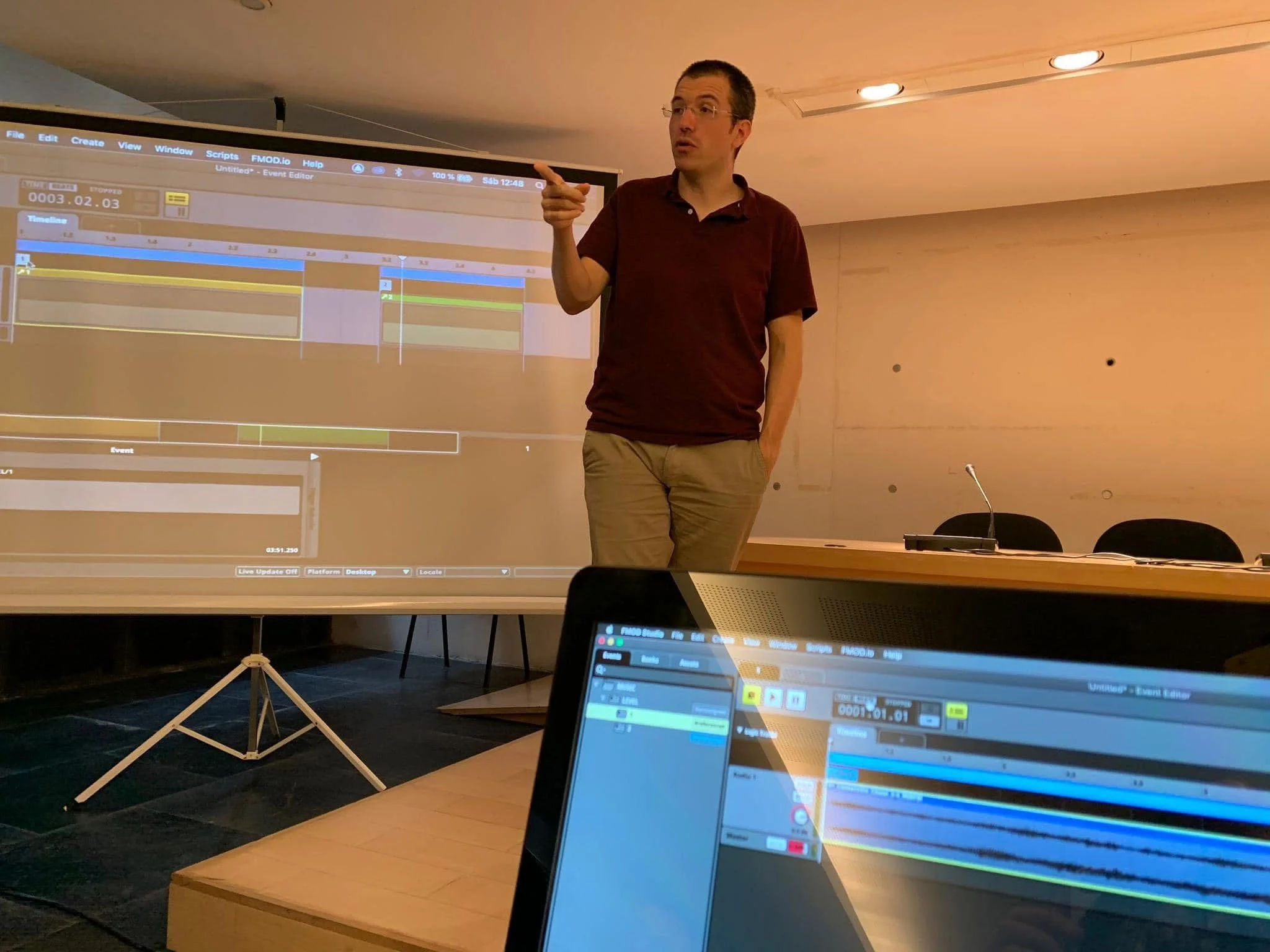 Lecture by Gerard Pastor, one hand in his pocket and the other pointing something out.